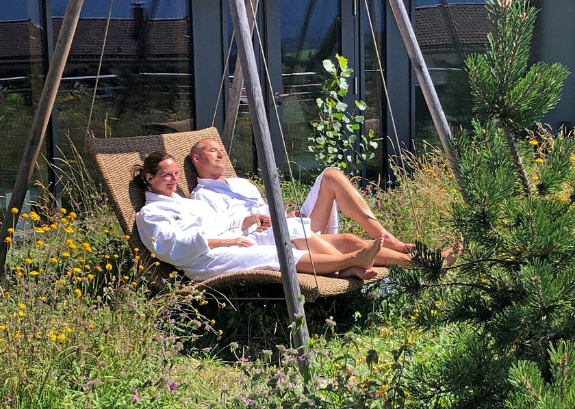 Paar in der Hängeliege im GartenSpa des mit 4 Wellness Stars ausgezeichneten Biohotel Eggensberger am Hopfensee im Allgäu