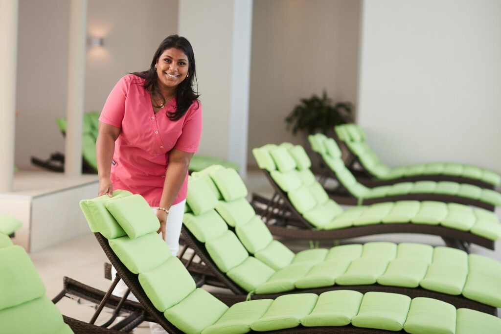 Spa-Mitarbeiterin richtet die Liegen im Ruheraum eines Wellneshotels