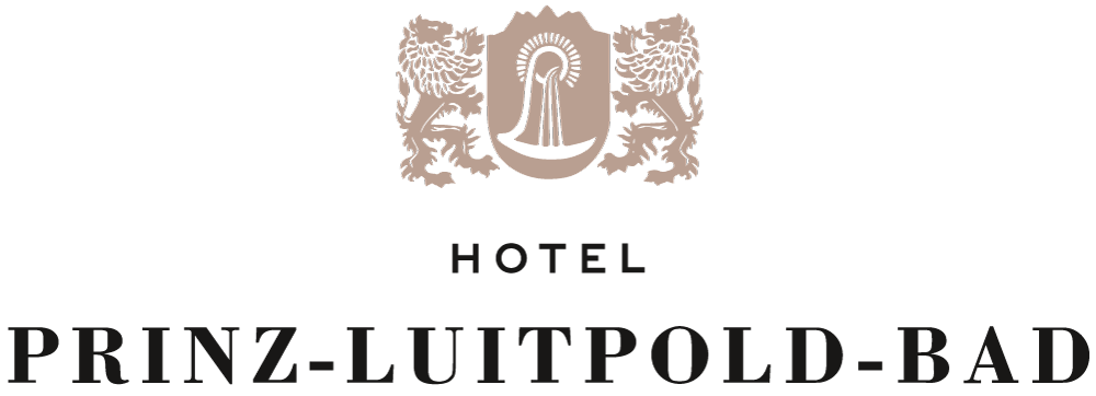 Logo für das Hotel Prinz-Luitpold-Bad mit einem Wappen, das zwei Löwen und ein zentrales Emblem zeigt, über dem der Hotelname in fetten schwarzen Buchstaben auf weißem Hintergrund steht.